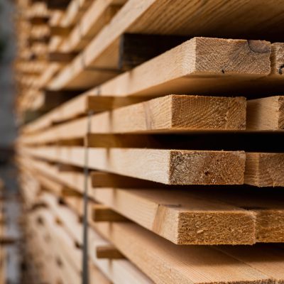 Piles of wooden boards in the sawmill, planking. Warehouse for sawing boards on a sawmill outdoors. Wood timber stack of wooden blanks construction material. Industry.