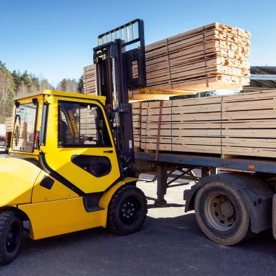 The machine loads the boards, lumber from the finished goods warehouse onto the truck
